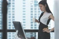 Business woman looking at computer monitor holding White coffee cup Royalty Free Stock Photo