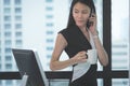 Business woman looking at computer monitor holding White coffee cup and using mobile phone Royalty Free Stock Photo