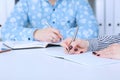 Business woman making notes at office workplace with male colleague at the background. Business job offer, financial Royalty Free Stock Photo