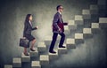 Business woman and man with briefcase stepping up a stairway career ladder Royalty Free Stock Photo