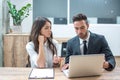 Business woman and man discussing project on laptop in office. Royalty Free Stock Photo