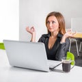 Business woman meditating near laptop. Relaxed office worker doing yoga meditation during a coffee break. Green eco healthy office Royalty Free Stock Photo