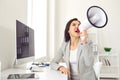 Business Woman with a megaphone in hand shouting while sitting at a table in the office Royalty Free Stock Photo
