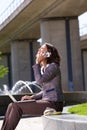 Business woman with mobile phone and laptop in city park Royalty Free Stock Photo