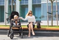 Business woman and mother working on laptop with baby in stroller Royalty Free Stock Photo