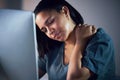 Business woman, neck pain and night in stress, burnout or fatigue by computer at office. Frustrated, overworked and Royalty Free Stock Photo