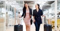 Business woman, phone and walking with luggage in travel for work trip partnership at the workplace. Happy women talking Royalty Free Stock Photo