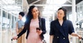 Business woman, phone and walking with luggage in travel for work trip partnership at the workplace. Happy women talking Royalty Free Stock Photo