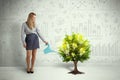 Business woman pouring water on lightbulb growing tree Royalty Free Stock Photo