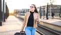 Business woman pulling suitcase at train station. Royalty Free Stock Photo