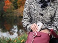 Business woman pulls a mobile phone from the bag. The woman takes the mobile phone out of the handbag. Royalty Free Stock Photo