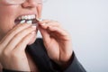 Business woman puts on transparent retainers to straighten teeth Royalty Free Stock Photo