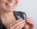 Business woman puts on transparent retainers to straighten teeth