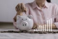 business woman putting coin on the piggybank and icon graph, saving, charity, finance plan Royalty Free Stock Photo