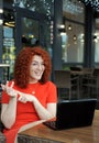 Curly hair business woman in red clothes works with laptop ooutdoors. Royalty Free Stock Photo