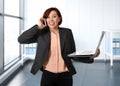 Business woman with red hair at work smiling with laptop computer talking busy on mobile phone Royalty Free Stock Photo