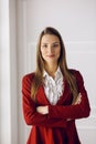 Business woman in red standing at modern office. Headshot of a young female entrepreneur