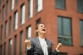 Business woman rejoicing in front of office