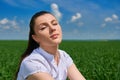 Business woman relaxing in green grass field outdoor under sun. Beautiful young girl dressed in suit resting, spring landscape, br Royalty Free Stock Photo