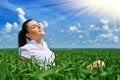 Business woman relaxing in green grass field outdoor under sun. Beautiful young girl dressed in suit resting, spring landscape, br Royalty Free Stock Photo