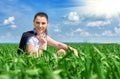 Business woman relaxing in green grass field outdoor under sun. Beautiful young girl dressed in suit resting, spring landscape, br Royalty Free Stock Photo