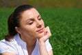 Business woman relaxing in green grass field outdoor under sun. Beautiful young girl dressed in suit resting, spring landscape, br Royalty Free Stock Photo