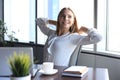 Business woman is relaxing with her hands behind her head and sitting on a chair in office Royalty Free Stock Photo