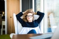 Business woman relaxing working at office desk laid back resting on chair with hands behind head. Royalty Free Stock Photo