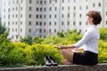 Business woman relaxing with yoga in the city