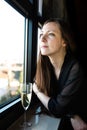 Business woman resting at the window with a glass of champaign