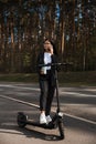 Business woman riding electric scooter at parking lot - Emission free eco friendly transportation