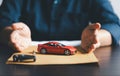 Business woman hand protecting red toy car on desk. Planning to manage transportation finance costs. Concept of car insurance Royalty Free Stock Photo