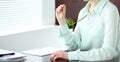 Business woman or secretary sitting at the desk in the office. Green toned image Royalty Free Stock Photo