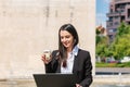 Business woman or secretary working on her laptop and having coffee on the street near the office Royalty Free Stock Photo