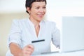 Business woman shopping online. Smiling mature business woman shopping online using laptop and credit card. Royalty Free Stock Photo