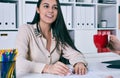 Young business woman showing growth graphic and taking to her female colleague who drinks coffee in an office interior. Royalty Free Stock Photo