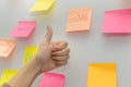 Business woman showing thumbs up with colored sheets sticky note paper on white board background Royalty Free Stock Photo