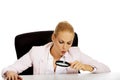 Business woman sitting behind the desk and looking into a magnifying glass Royalty Free Stock Photo