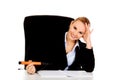 Business woman sitting behind the desk and writes something with big pen Royalty Free Stock Photo