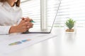 A business woman sitting on a desk with a laptop and graph with gestures in the office Concept .Take a break from the computer.And Royalty Free Stock Photo