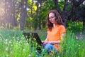 Business woman sitting with laptop in the park, free space. Royalty Free Stock Photo