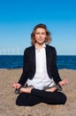 Business woman sitting in lotus pose on the beach Royalty Free Stock Photo