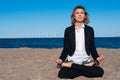 Business woman sitting in lotus pose on the beach, Royalty Free Stock Photo