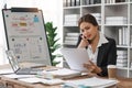 business woman sitting at office desk in front of laptop hold mobile phone make pleasant business or informal call Royalty Free Stock Photo