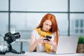 Business woman sitting in office, looking at graphics and uses smartphone Royalty Free Stock Photo