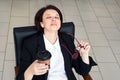 Business woman sitting relaxed on a chair leaning back with closed eyes during coffee break Royalty Free Stock Photo