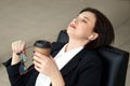 Business woman sitting relaxed on a chair leaning back with closed eyes during coffee break Royalty Free Stock Photo