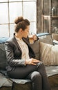 Business woman sitting on sofa and drinking coffee in loft Royalty Free Stock Photo