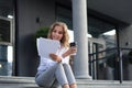 Business woman sitting on the stairs looking documents, graphs and charts Royalty Free Stock Photo