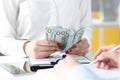 Business woman sitting at table with colleagues and counting money closeup Royalty Free Stock Photo